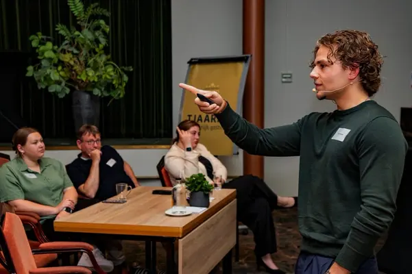 Spreker in gesprek met een kleine groep deelnemers tijdens een AI-sessie