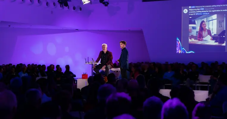 Twee sprekers op het podium bij een demonstratie van AI-beeldgeneratie