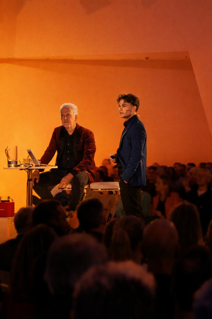 Sonny de Leeuw en Wouter de Vries op het podium tijdens een AI-lezing, met publiek op de voorgrond