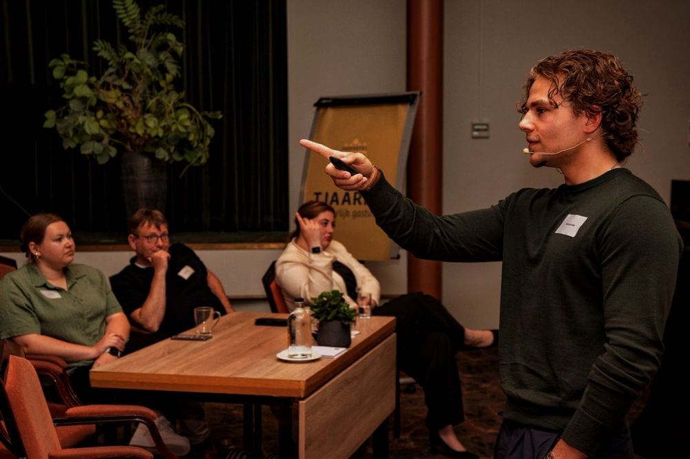 Speaker in conversation with a small group of participants during an AI session