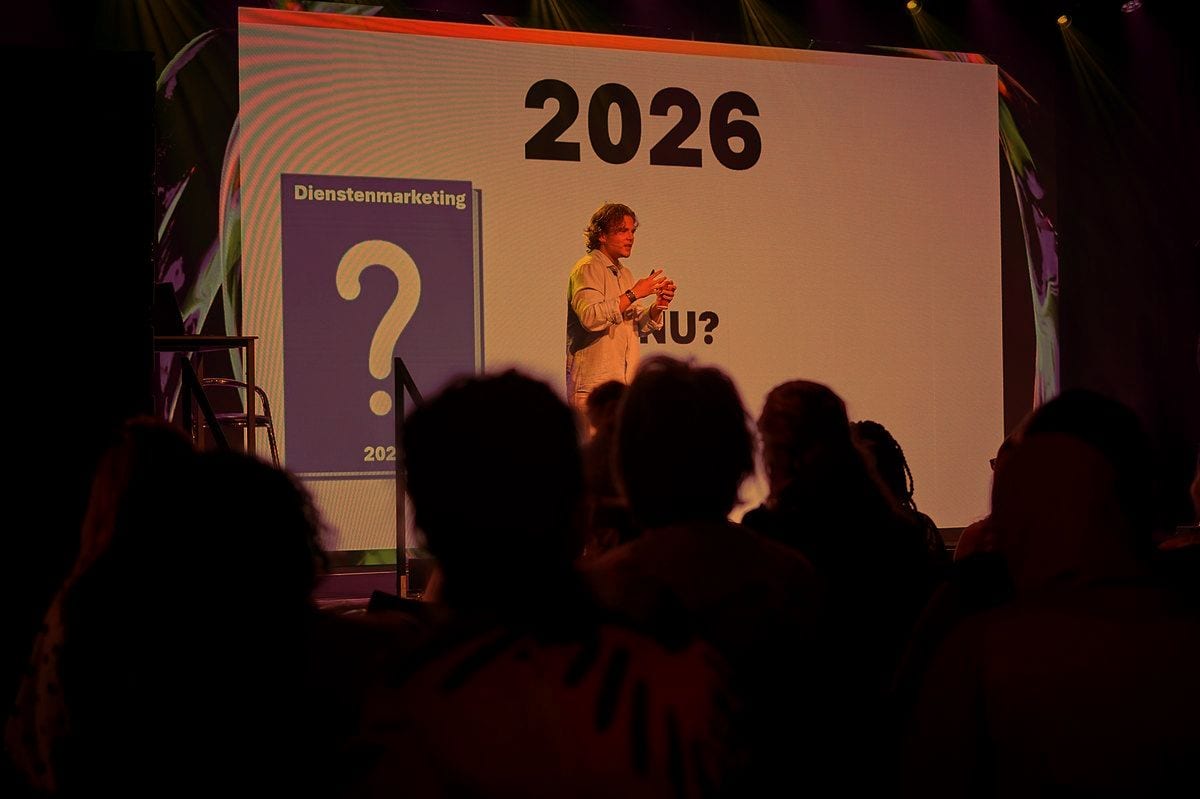 Speaker in front of a large screen showing the year 2026 during a talk on AI developments